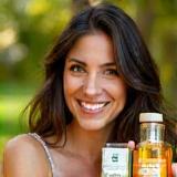 Foto de cliente Julia Vieira ao ar livre sorrindo com produtos Beleza Artesanal
